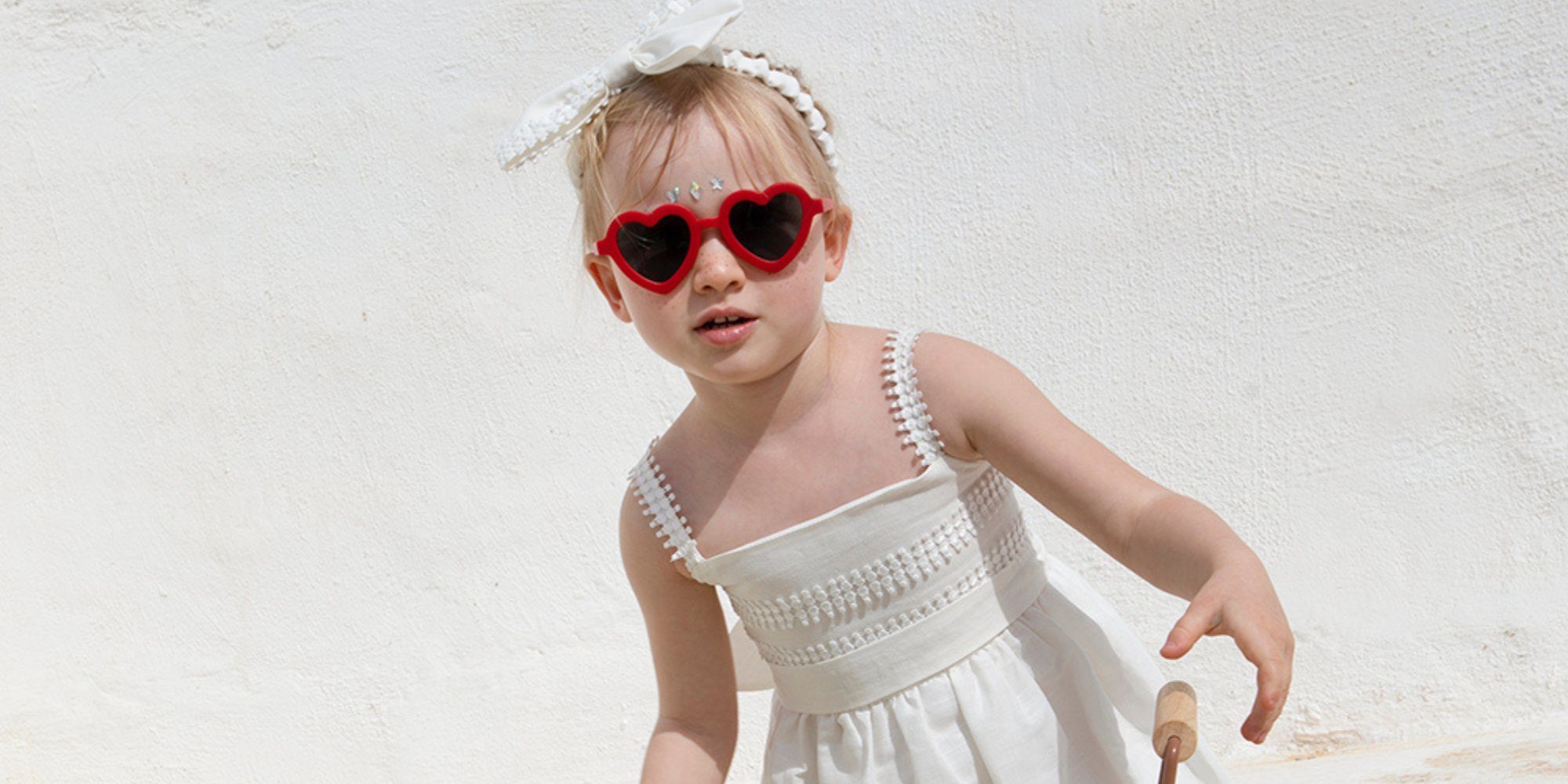 Ένα κοριτσάκι φοράει ένα βαπτιστικό φουστανάκι.